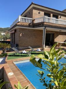 卡涅利亚斯Villa Belephant Sitges的一座房子前面设有游泳池