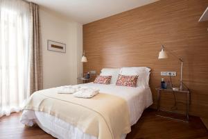 桑卢卡尔-德巴拉梅达La Alcoba del Agua hotel boutique的一间卧室设有一张带木墙的大床