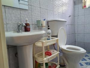 恩德培Dees shared home away from home的浴室配有白色水槽和卫生间。