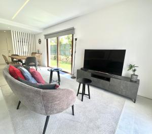 维拉摩拉Vila Ruby - Private Pool by HD PROPERTIES的带沙发和平面电视的客厅