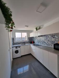 圣地亚哥港VILLA LORA Modern & New townhouse 2 Bedroom的厨房配有白色橱柜和洗衣机。