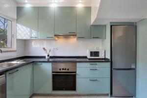 韦尔都勒博Villa Isabel的厨房配有蓝色橱柜和微波炉