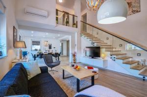 巴尔巴里加Villa Anna Barbariga, NEW 2022 luxurious villa with private pool!的客厅设有蓝色的沙发和楼梯。