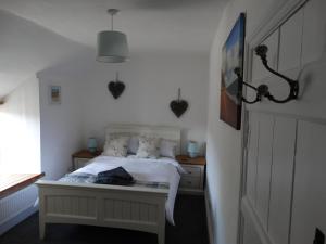 布里德波特Staddlestones Cottage的一间卧室设有一张床和一个窗口
