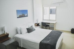 卡塔赫纳Hotel El Marqués De Manga的一间卧室配有一张床、一张书桌和一个窗户。