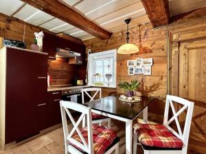大舍瑙Rustikales Studio-Apartment Blockstube im Haus Selma的厨房配有桌椅和冰箱。