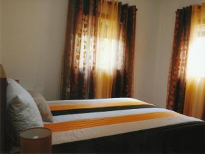 BesteirosCasa Quelhas的卧室内的一张床位,配有窗帘和窗户
