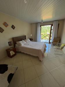 多明戈斯马丁斯Chalé Vista Azul的一间卧室设有一张床和一个大窗户