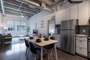 亚特兰大Stylish City Living Apartments with Free Parking in Midtown Atlanta的厨房配有桌子和不锈钢冰箱。