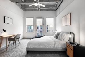 亚特兰大Stylish City Living Apartments with Free Parking in Midtown Atlanta的卧室配有一张床、一张书桌和窗户。