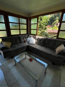 多明戈斯马丁斯Chalé Vista Azul的带沙发和玻璃茶几的客厅
