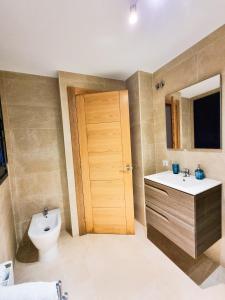 库迪列罗BarloventoCudillero的一间带卫生间、水槽和门的浴室