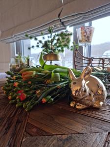 米兹多洛杰Apartament Prestige & Sea Balticus A4的一张桌子上放着小兔子和鲜花