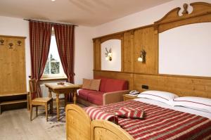 布雷斯高山客栈酒店的一间卧室配有一张床、一张沙发和一张桌子
