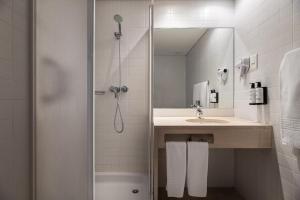 法蒂玛Crisol Tres Pastorinhos的带淋浴、盥洗盆和浴缸的浴室