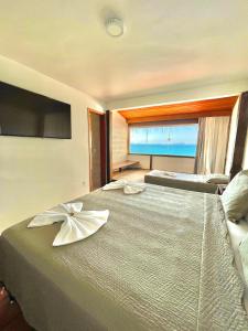 阿拉亚尔-杜卡布Orlanova Hotel的一间卧室设有两张床和大窗户