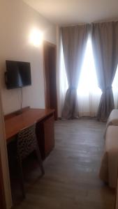 波吉邦西托斯卡纳大使酒店的客房设有书桌、电视和窗户。