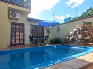 伊瓜苏港Salto dos hermanas的一座带瀑布的房屋前的游泳池