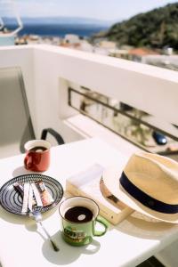 圣加利尼Lefka Ori - Agia Galini的一张桌子,上面放着两杯咖啡和一顶帽子