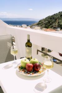 圣加利尼Lefka Ori - Agia Galini的桌上一盘苹果和一瓶葡萄酒