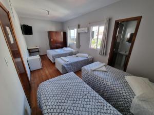布卢梅瑙赫尔曼酒店的带三张床和镜子的客房