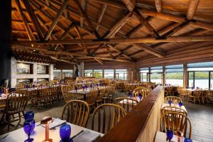 克奇坎Salmon Falls Resort的用餐室设有桌椅和木制天花板