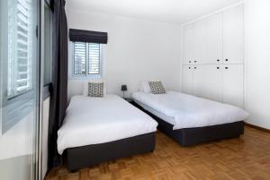 尼科西亚Urban Condo 12 - 2 Bdr的配有2张床的白色墙壁和窗户。