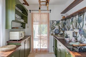 加尔多尼Casa Elisabetta Apartmanház的厨房设有绿色橱柜和窗户。