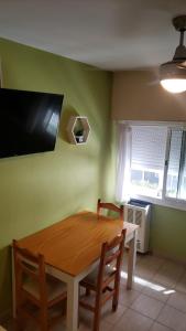 马德普拉塔Excelente monoambiente completo, funcional y muy cómodo - Zona "Aldrey"的餐桌、两把椅子和墙上的电视
