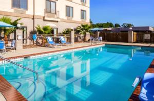 利文斯顿Americas Best Value Inn & Suites-Livingston的一座带蓝色椅子的大型游泳池和一座建筑