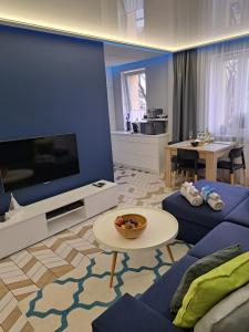 奥古斯图Apartament Augustów SWAN的客厅配有大屏幕电视和沙发。