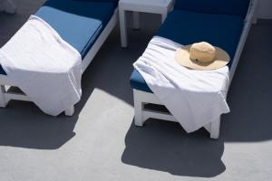 VourvoúlosWhite Swallow Suite Santorini的配有2张床的宿舍间,配有帽子
