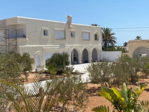斯法克斯Villa Luna Domaine Béluga Bounouma kerkennah的沙漠中的一个白色房子