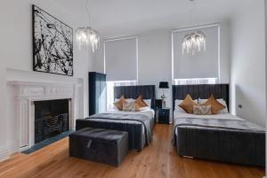 利物浦80 by Elite的一间卧室设有两张床、一张沙发和一个壁炉