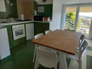 维拉西米乌斯Casa Buenavista Villasimius的厨房配有木桌和白色椅子