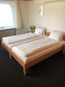 迈恩费尔德海迪豪弗酒店和餐厅的卧室内的一张带白色床单和枕头的大床