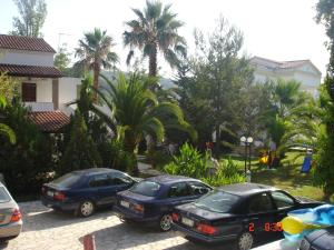 斯达林玛丽莲公寓式酒店的三辆汽车停在一个棕榈树停车场