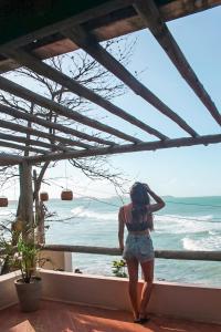 皮帕Abacate Casa do Mar的站在一个眺望海洋的阳台上的女人
