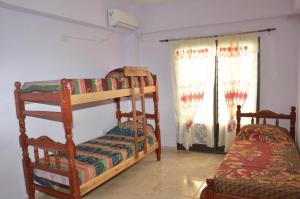 El CarmenApartamentos Naomi 1B的一间卧室设有两张双层床和一扇窗户。