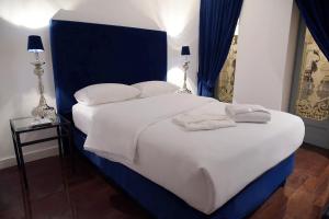 普埃布拉Palacio Julio Hotel的卧室配有一张带白色床单和枕头的大床。