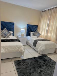理查兹湾Isibani luxury apartment的一间带两张床的卧室和地毯