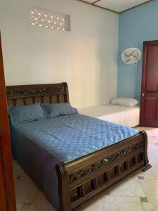 米卡Casa Hotel Arcadia Minca的一间卧室配有一张带蓝色床单的床和一扇窗户。