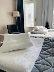 VihtiPolku Hotelli的一间卧室配有两张床和白色毛巾。