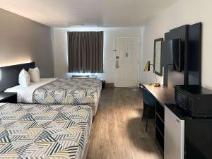萨凡纳Motel 6-Pooler, GA - Savannah Airport的酒店客房设有两张床和一台平面电视。