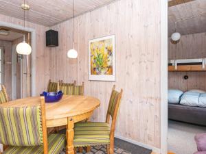 格雷诺9 person holiday home in Grenaa的一间带木桌和椅子的用餐室