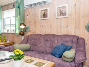 格雷诺9 person holiday home in Grenaa的客厅配有紫色沙发和桌子