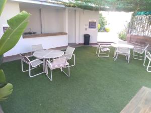 库利亚坎Hotel Maioris Bellavista的一间设有桌椅的客房,位于绿色地毯上