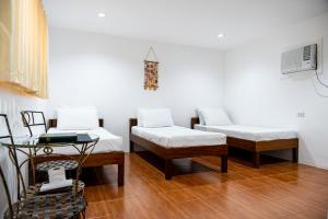 San MateoCiudad Christhia Resort, 9 Waves的一间设有两张床和一张桌子的房间