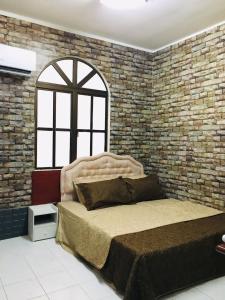 瓜埠赛丽拉吉达公寓的一间卧室设有一张大床和砖墙