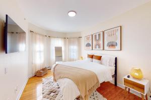波士顿Five75 Lux BOS - Boho Chic的一间白色卧室,配有一张大床和一台电视